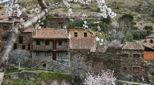 Casas de piedra con tejados rojos en un pueblo de montaña, ideal para saber como ir a la sierra de Madrid en primavera.