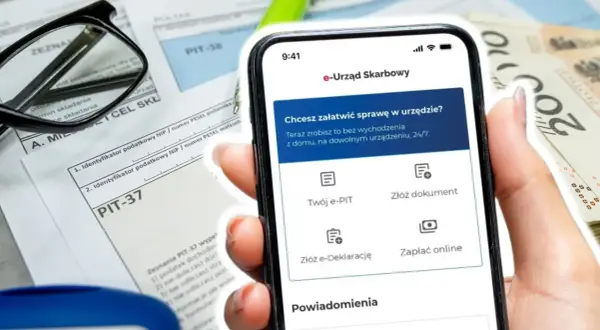 Telefon z aplikacją e-Urząd Skarbowy obok formularzy PIT i pieniędzy. Wpisz swój numer identyfikacji podatkowej, by załatwić sprawy urzędowe online.