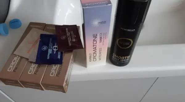 Butelka serum Montibello Smooth Sleek Serum, pudełko z tonerem do włosów Cromatone i próbki kosmetyków.