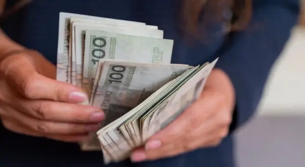 Dłonie liczą banknoty 100 zł. Czy to tyle, ile zarabia aktor w Ukrytej Prawdzie?