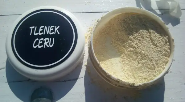 Puszka z napisem "TLENEK CERU" obok otwartego pojemnika z żółtym proszkiem.