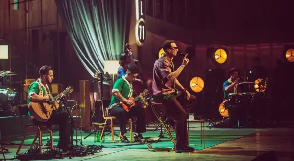 Zespół Mrozu na scenie MTV Unplugged. Wokalista śpiewa, gitarzyści grają, a perkusista wybija rytm.