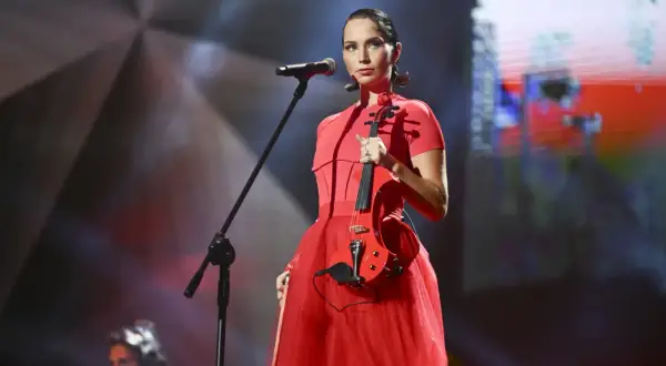 Mery Spolsky na koncercie w czerwonej sukni, trzymająca czerwoną gitarę elektryczną.