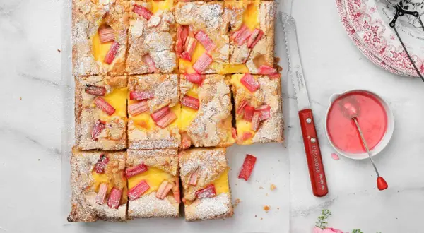 Sliced vanilla squares with rhubarb and custard, dusted with powdered sugar.