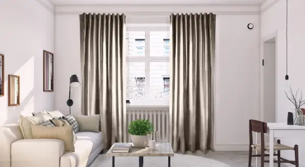 Mysig vardagsrumsmiljö med beiga sammetsgardiner som ger perfekt gardin inspiration. En vit soffa och ett runt soffbord skapar en inbjudande känsla.