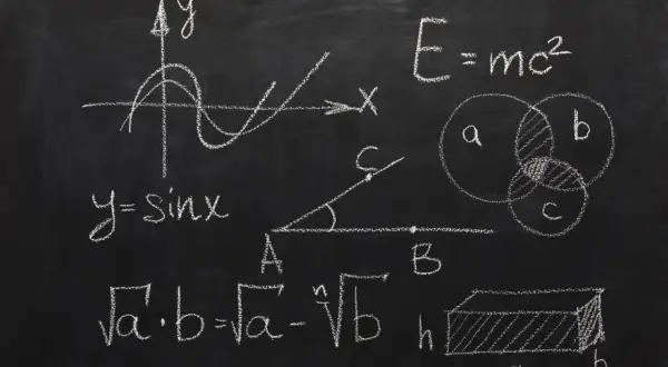 Rysunki matematyczne na tablicy: wykres funkcji sinus, wzory, diagramy Venna, bryła.