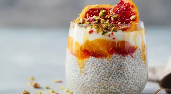 En läcker chiapudding med kvarg, apelsin och blodapelsin, toppad med pistagenötter.