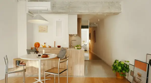 Stilvolle Einrichtung einer 45 qm Wohnung mit Esstisch, Küche und Blick ins Schlafzimmer. Helle Farben und Holzmöbel schaffen Gemütlichkeit.