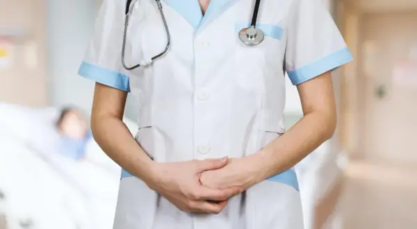 Een verpleegkundige met stethoscoop, klaar om zorg te verlenen. De sfeer doet denken aan het Florence Nightingale syndroom, waar empathie en toewijding centraal staan.