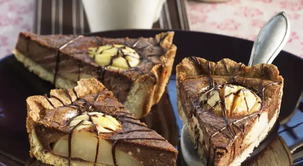 Drei Stücke saftiger Birnen Schoko Kuchen auf einem Teller, verziert mit Schokoladenglasur und Birnenstücken.