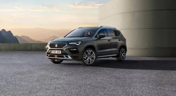 SUV Seat Ateca, con le sue dimensioni perfette per ogni avventura, parcheggiato all'esterno con un paesaggio montano sullo sfondo.