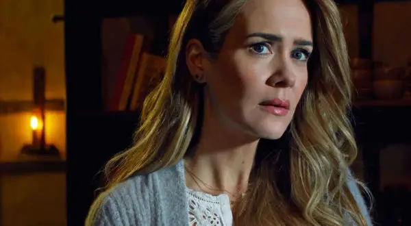 Sarah Paulson w filmach, serialach i programach, z zapaloną świecą w tle.