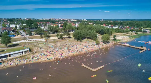 Tłoczna plaża nad zalewem w Starachowicach, pełna ludzi kąpiących się i opalających. Idealne starachowice atrakcje dla dzieci i dorosłych w słoneczny dzień.