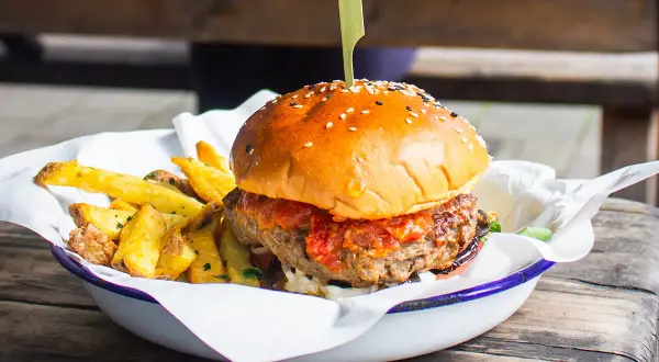 Soczysty burger z frytkami, idealne kaloryczne przekąski na masę.