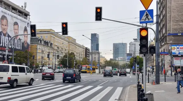 Skrzyżowanie z sygnalizacją świetlną, tramwajem i samochodami. Zastanawiasz się, po jakim czasie przychodzi mandat za przejazd na czerwonym świetle?