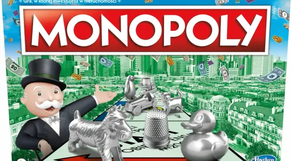 Pudełko gry Monopoly z Mr. Monopoly, pionkami i pieniędzmi na tle miasta.