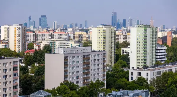 Widok na osiedle mieszkaniowe z blokami i wieżowcami w tle. Zastanawiasz się, jak ubezpieczyć mieszkanie?