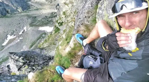 Mężczyzna na szczycie, delektuje się kanapką podczas prawdziwego hiking po polsku. Widok zapiera dech!