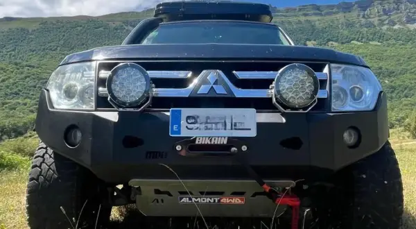 Mitsubishi Montero V80 preparado para aventura, con parachoques reforzado, focos potentes y techo solar.