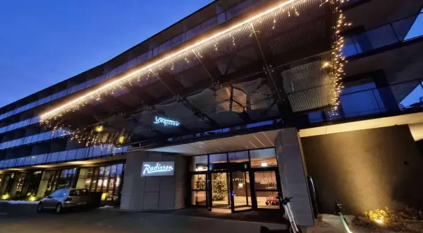 Wejście do hotelu Radisson Resort Kołobrzeg nocą, ozdobione lampkami.