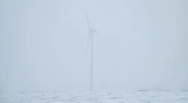 Wiatr huczy jak wiersze o smutku i żalu. Samotna turbina na zaśnieżonym polu, w mglistym, przygnębiającym krajobrazie.