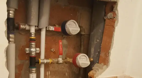 Instalacja wodna z dwoma wodomierzami i zaworami. To jest właśnie armatura, która pozwala kontrolować przepływ wody.