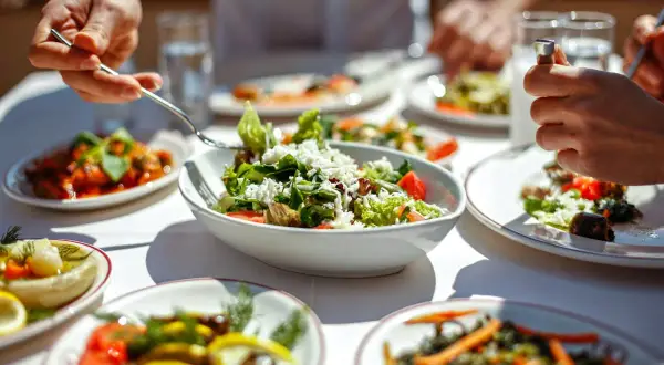 Un repas convivial avec des salades fraîches et des légumes colorés, parfait pour un rééquilibrage alimentaire.