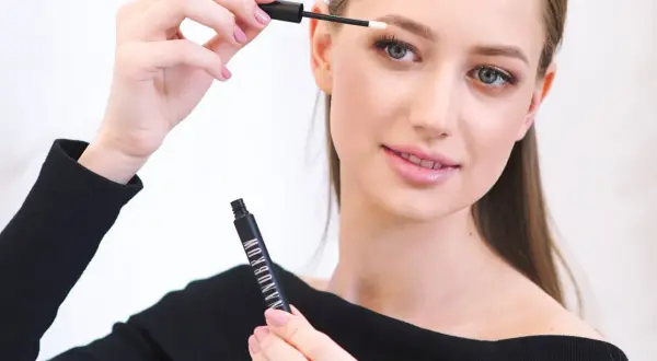 Kobieta aplikuje produkt do brwi Nanobrow, tworząc perfekcyjny makijaż.
