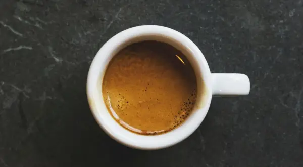 En vit kopp med en gyllene crema, perfekt för en intensiv ristretto vs espresso.
