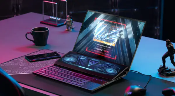 Laptop z ekranem głównym wyświetlającym specyfikację AMD Radeon 680M na procesorze Ryzen 7/9. Obok klawiatura i dodatkowy ekran.