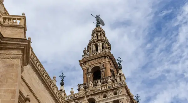 Wspaniała wieża w **Sevilla miasto** z figurą na szczycie i napisem "PROVERBIO".