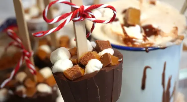 Chokladkoppar med marshmallows och kola, redo att smältas ner i varm choklad. En härlig juldekoration.