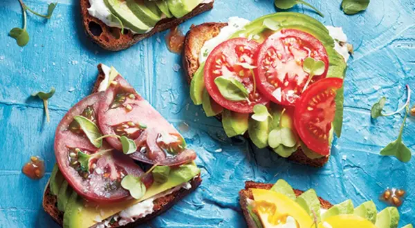 Tartines gourmandes : une recette avocat simple et savoureuse avec tomates fraîches et pousses croquantes sur pain grillé.