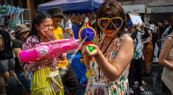 Tajlandia ludność bawi się na festiwalu Songkran, strzelając do siebie z pistoletów na wodę.