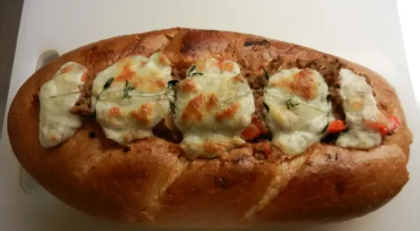 En gyllene, fylld fransk baguette med smält ost och örter.