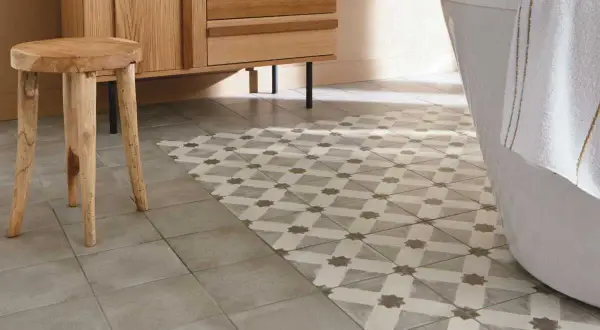 Un sol de salle de bain avec deux types de carrelage : un uni gris et un à motifs géométriques. Une idée pour peindre carrelage sol et moderniser une pièce.