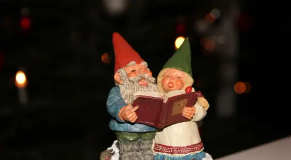 Dwa krasnale śpiewają kolędę "Cicha noc", trzymając otwartą książkę.