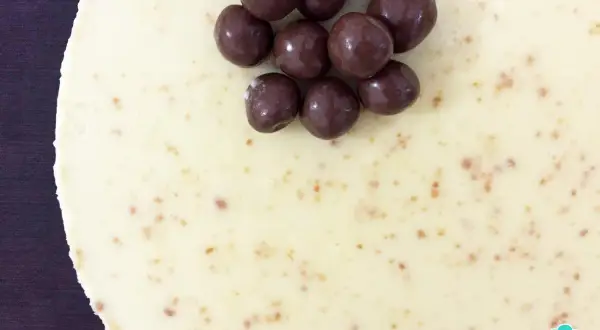 Deliciosa tarta de chocolate blanco, cubierta con crujientes bolitas de chocolate oscuro. ¡Un postre irresistible!