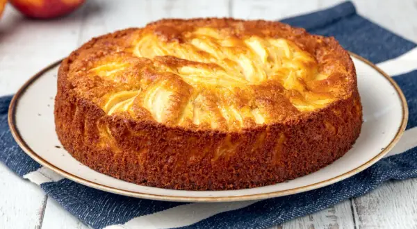 Torta semplice di mele, dorata e profumata, pronta per essere gustata.