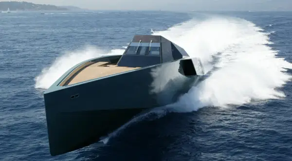 Un elegante yacht, forse quello di Gianluca Vacchi, sfreccia sull'acqua blu, lasciando una scia bianca.