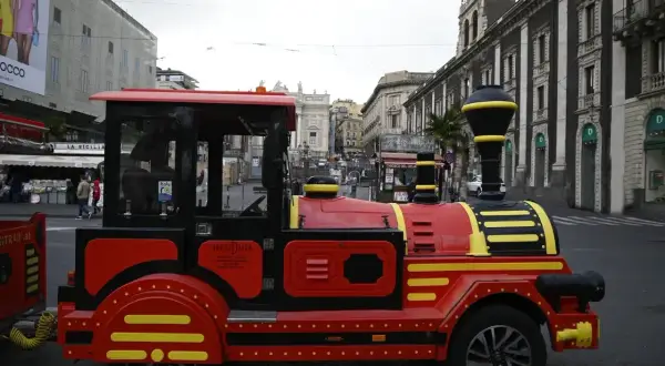 Czerwony pociąg turystyczny na ulicach Katanii Syrakuzy, idealny do zwiedzania.