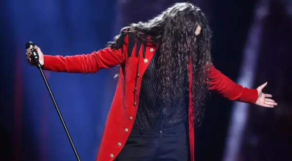 Michał Szpak w czerwonym fraku śpiewa na Eurowizji 2016.