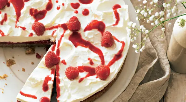 Himbeer Sahne Torte mit frischen Beeren und rotem Fruchtpüree, ein Genuss für Augen und Gaumen.