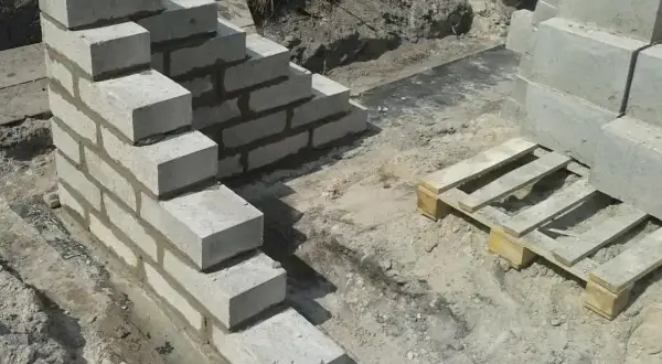 Budowa schodów z bloczków betonowych, gdzie zaprawa murarska do bloczków betonowych spaja kolejne warstwy.