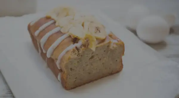 Ein saftiges Bananenbrot ohne Zucker, verziert mit Zuckerguss und Bananenchips. Perfekt für einen gesunden Genuss.