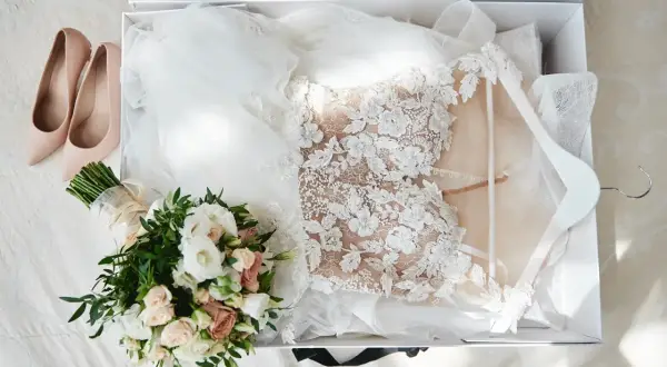 Brautkleid, Schleier, Brautstrauß und zarte Pumps liegen bereit. Alles für das Getting ready Hochzeit.
