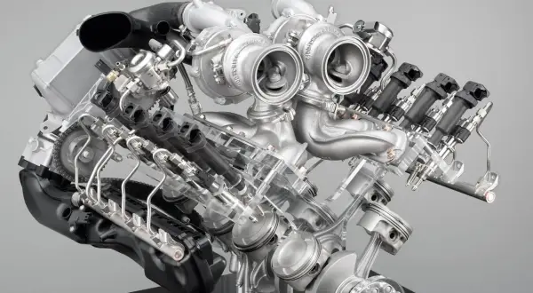 Detaljerad vy av en BMW V8-motor med dubbelturbo. Synliga kolvar, vevaxel och insprutningssystem.