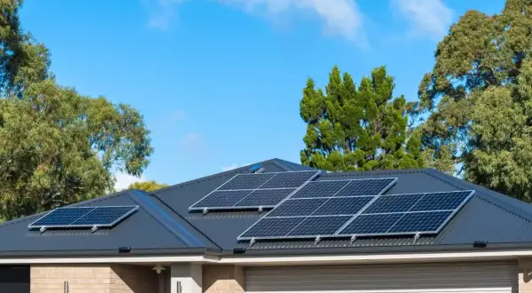 Pannelli solari sul tetto di una casa, con alberi sullo sfondo. Si valuta il collegamento pannelli solari in serie o parallelo per massimizzare l'energia.