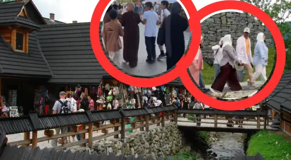 Grupa arabów w Zakopanem spaceruje po drewnianym moście, podziwiając góralski folklor i stragany z pamiątkami.
