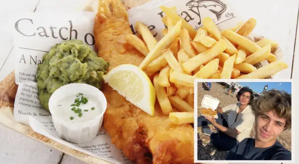 Dos jóvenes disfrutan de un clásico plato de comida inglesa: fish and chips, servido con puré de guisantes y salsa tártara.